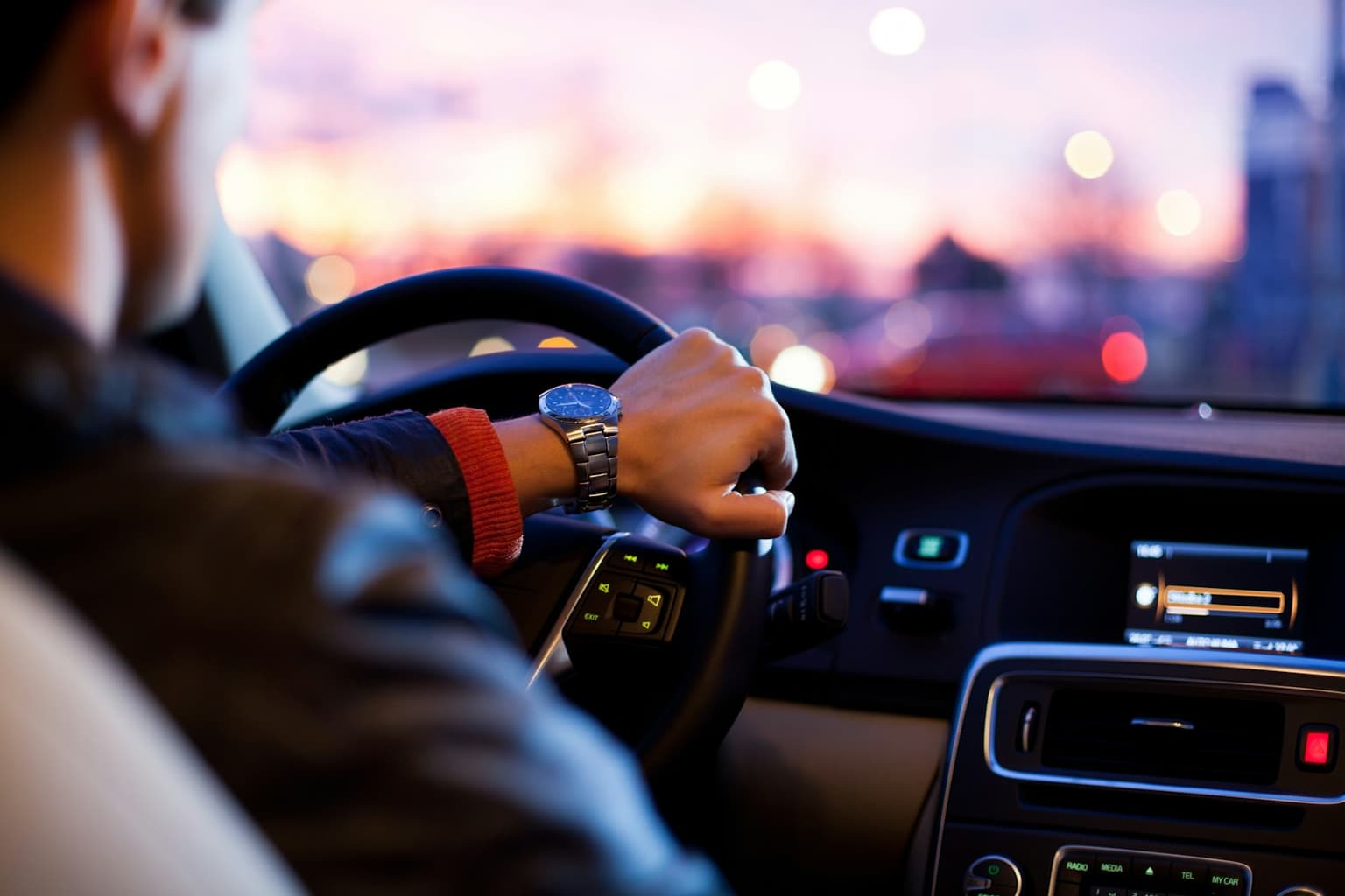 A driver at the wheel of a car at dusk